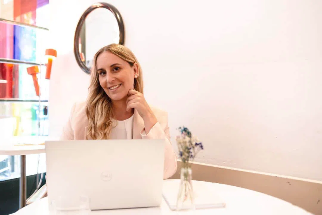 Nicole Randoll, Absolventin der Mediationsausbildung, lächelnd am Laptop